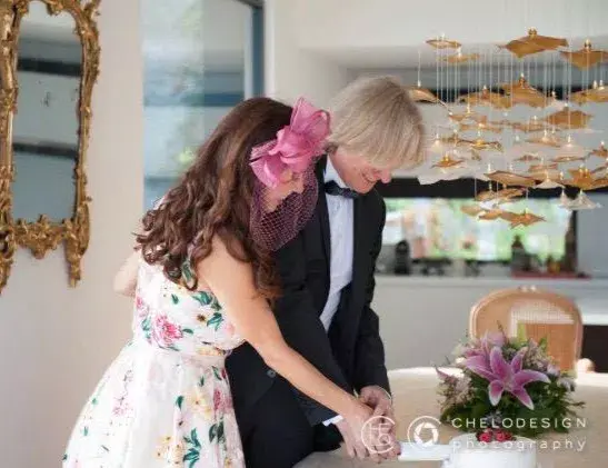 Cutting wedding cake under FOSALI INFINITO modern chandelier