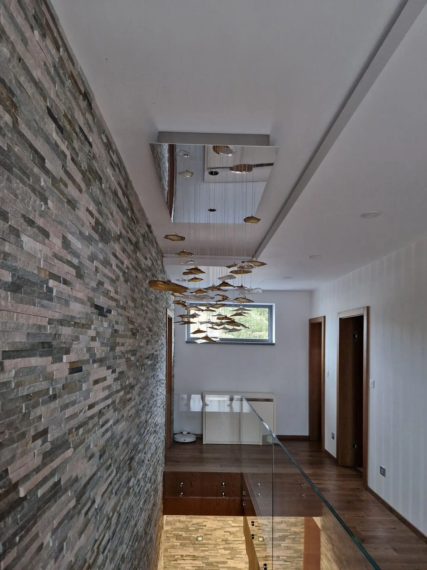 Fiber optic chandelier INFINITO above staircase during daytime when switched off