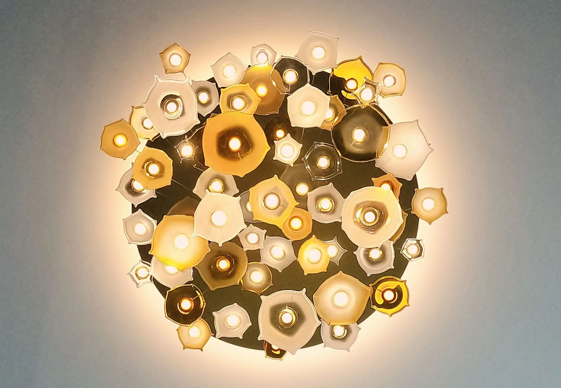 LED infinito is LED chandelier with organic shaped glass leafs hanging on transparent cables.