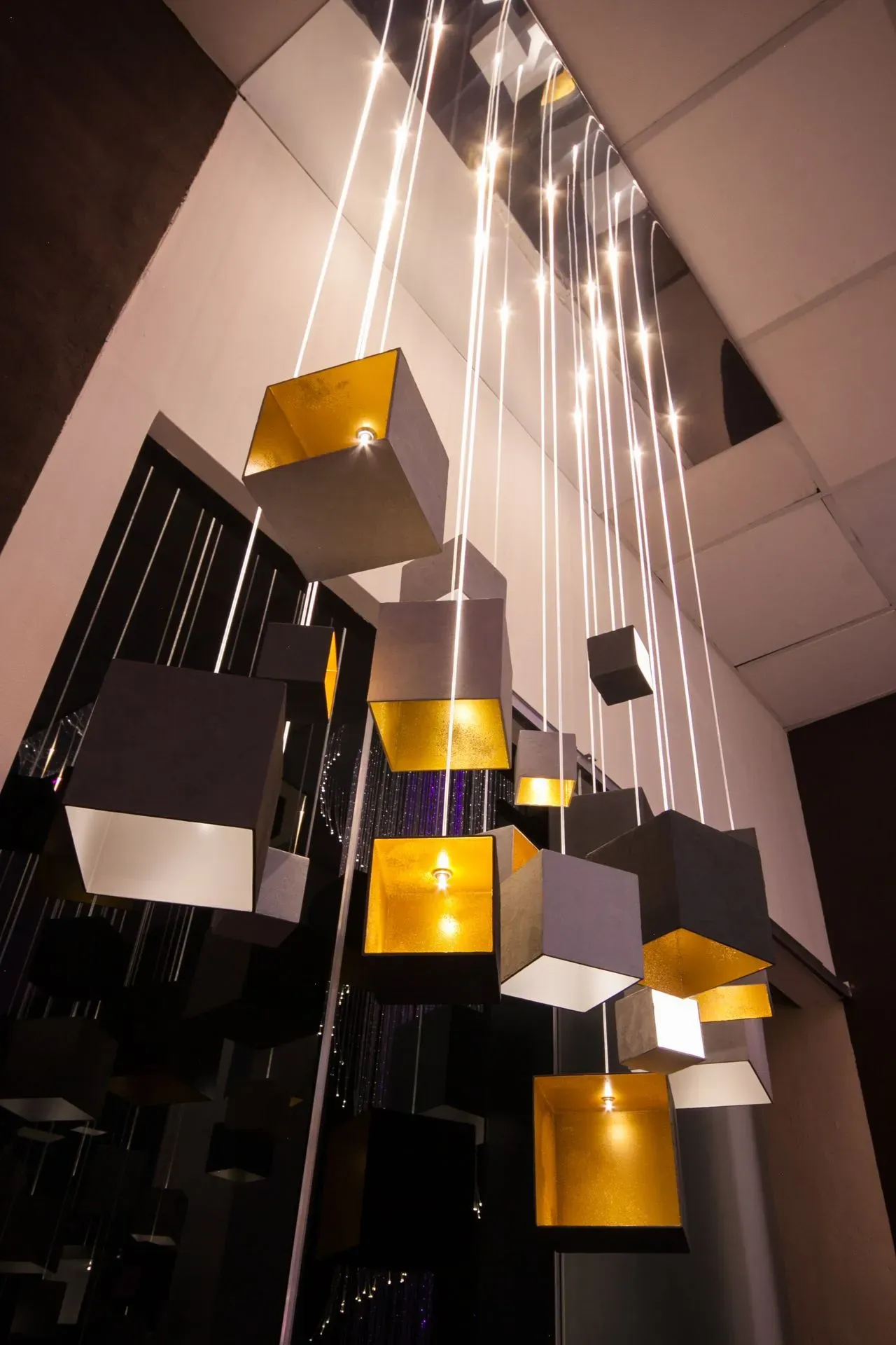 Gold GRAIN chandelier for modern interior with minimalistic concrete design made of fibre optic showroom